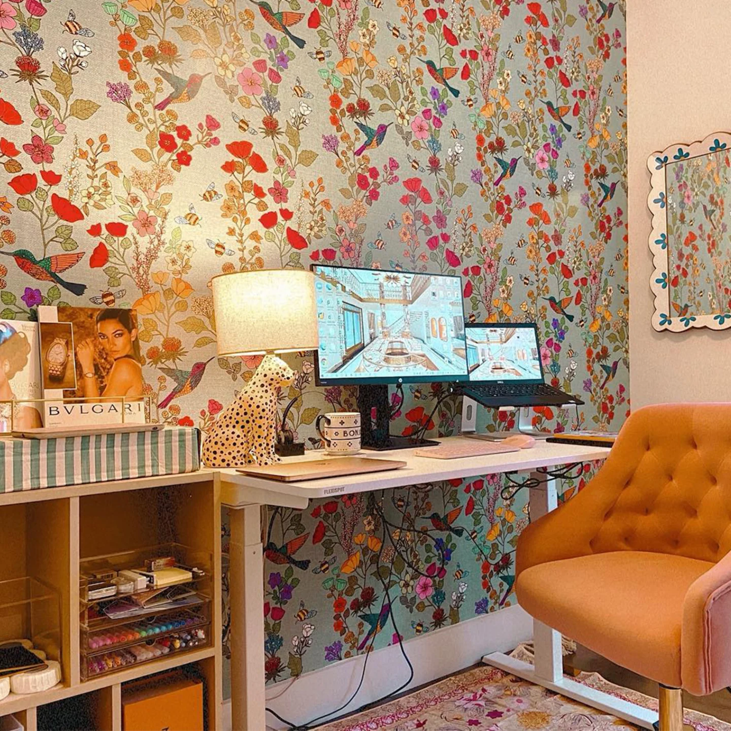 Colorful floral and bird wallpaper with an office desk in front of it.