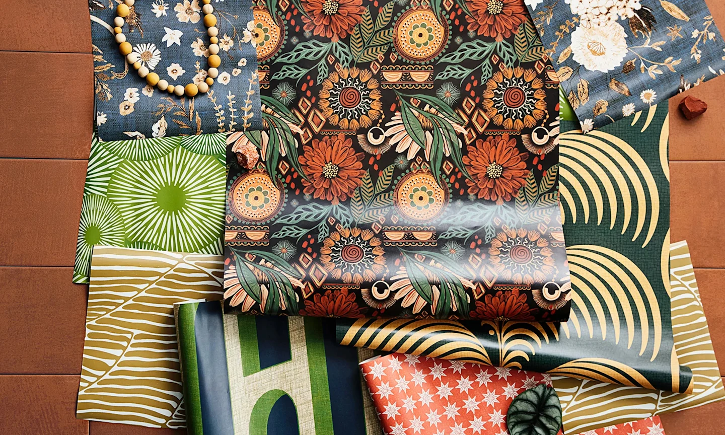 Boho style peel and stick wallpaper rolls and swatches styled together.