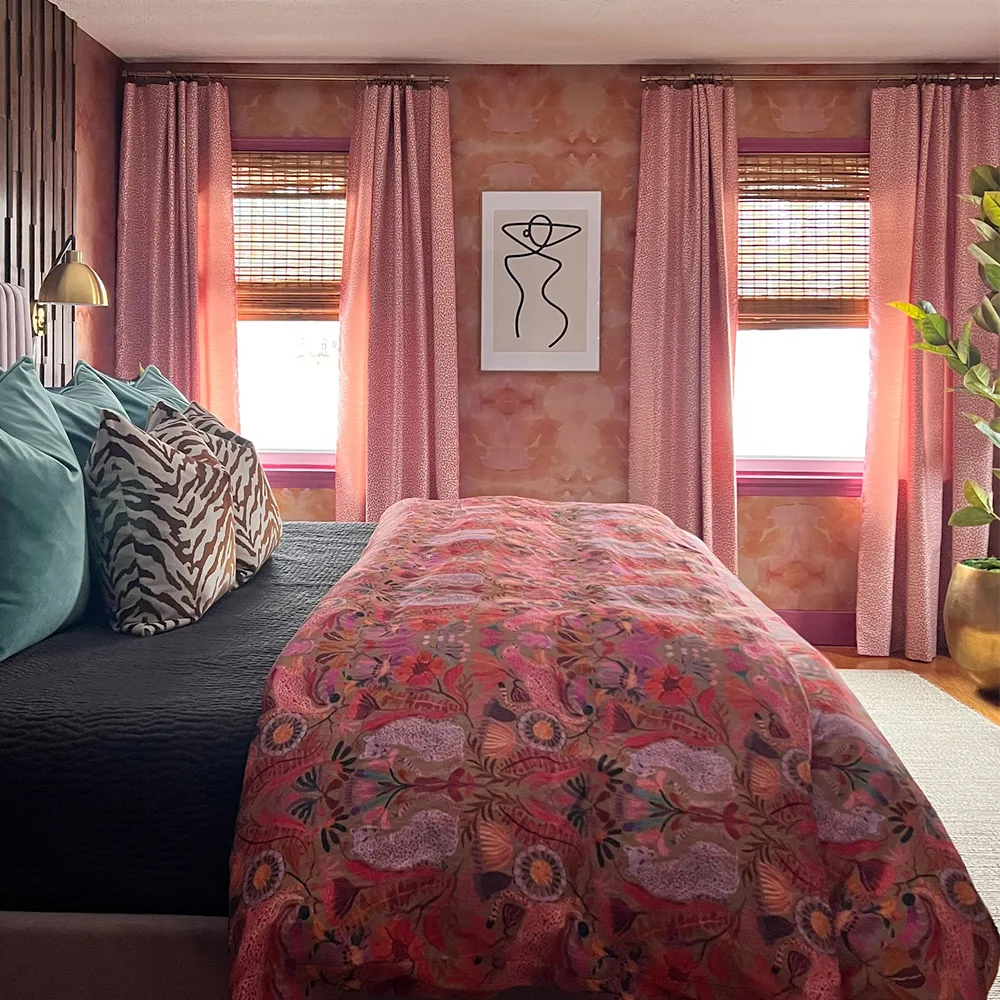 Bedroom with pink abstract wallpaper and bedding.