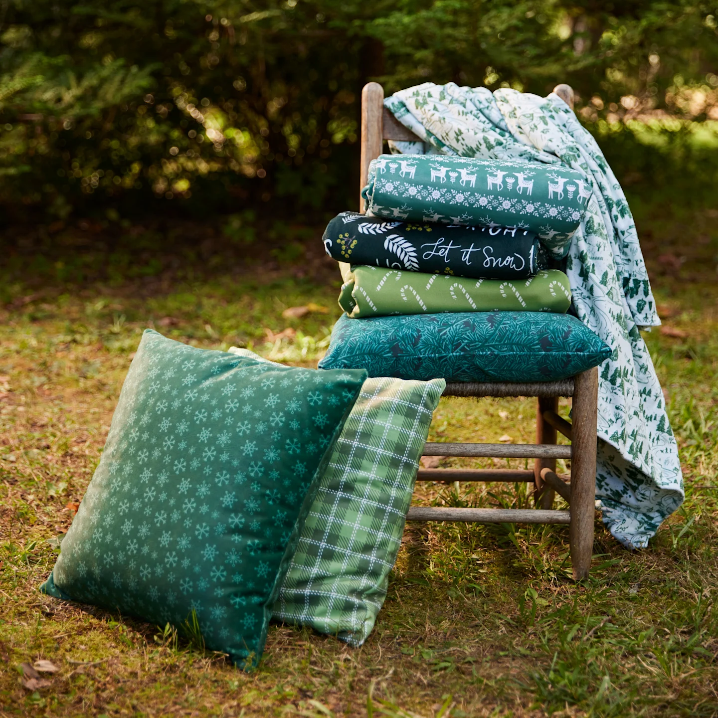 Square throw pillows stacked on a chair outdoors