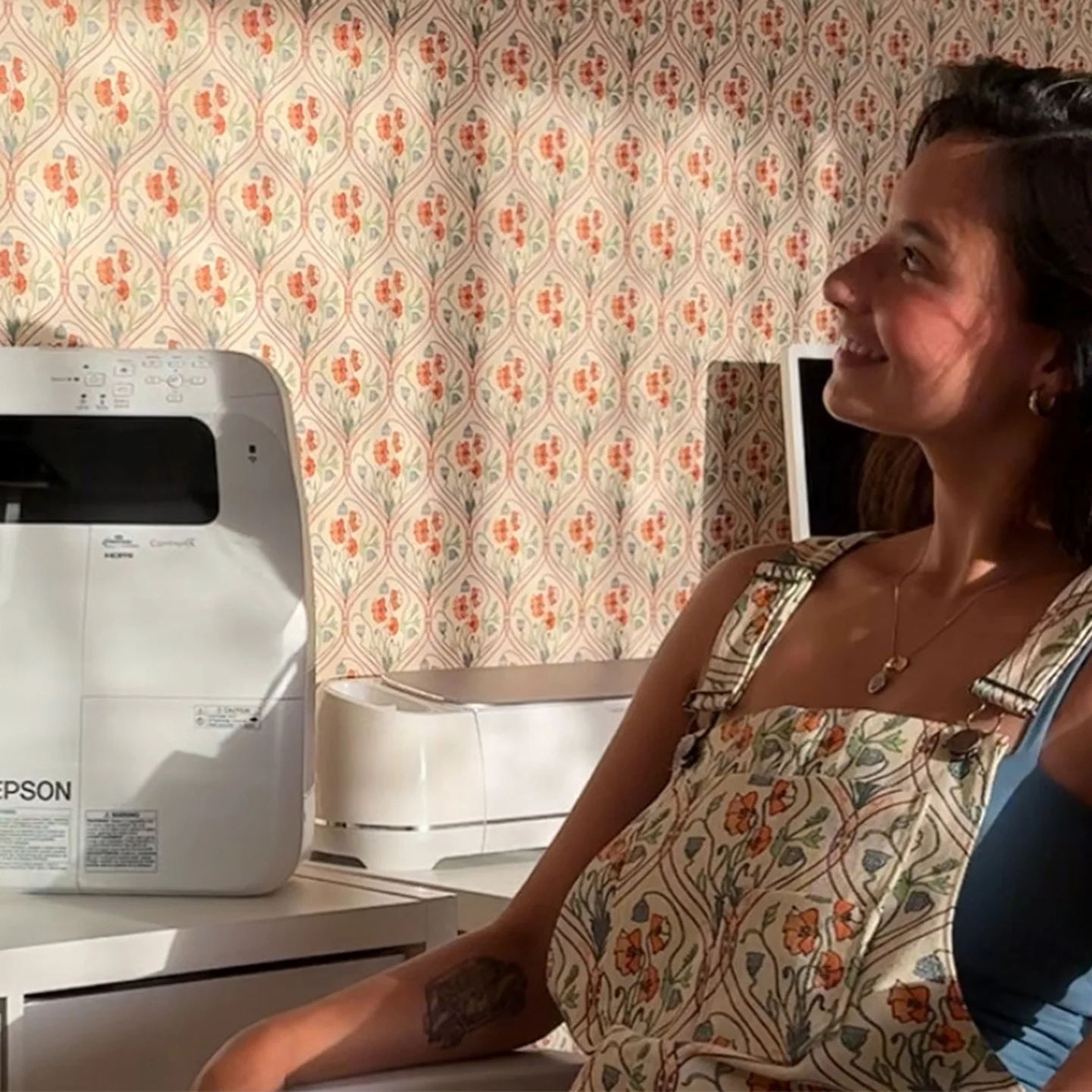 Mya Riviera in overalls she made with matching wallpaper.