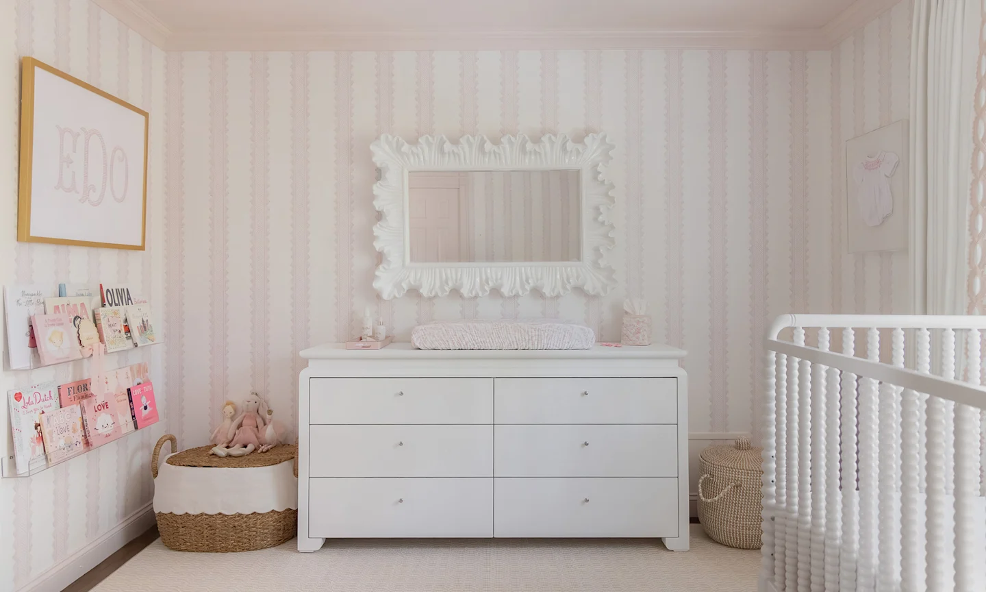 Nursery with pink stripe wallpaper.