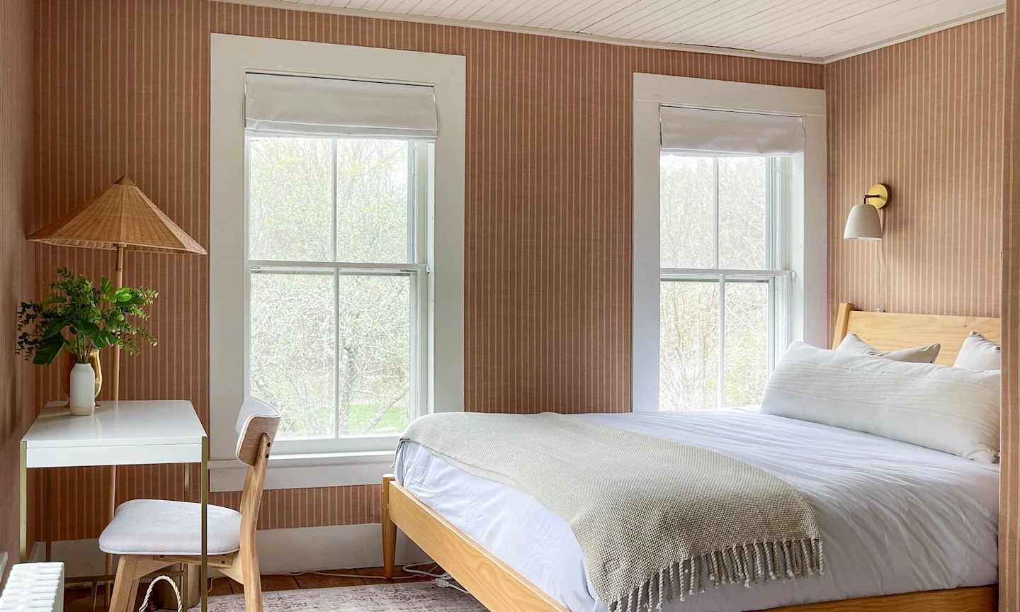 Bedroom with mauve striped wallpaper.